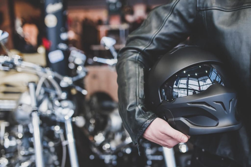 バイクとヘルメットを持つライダー